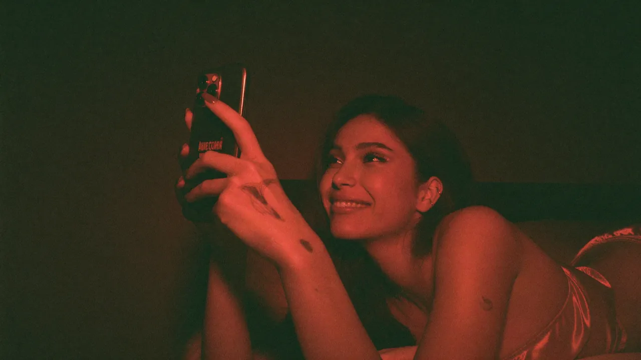 A creator taking a photo of herself in red neon light